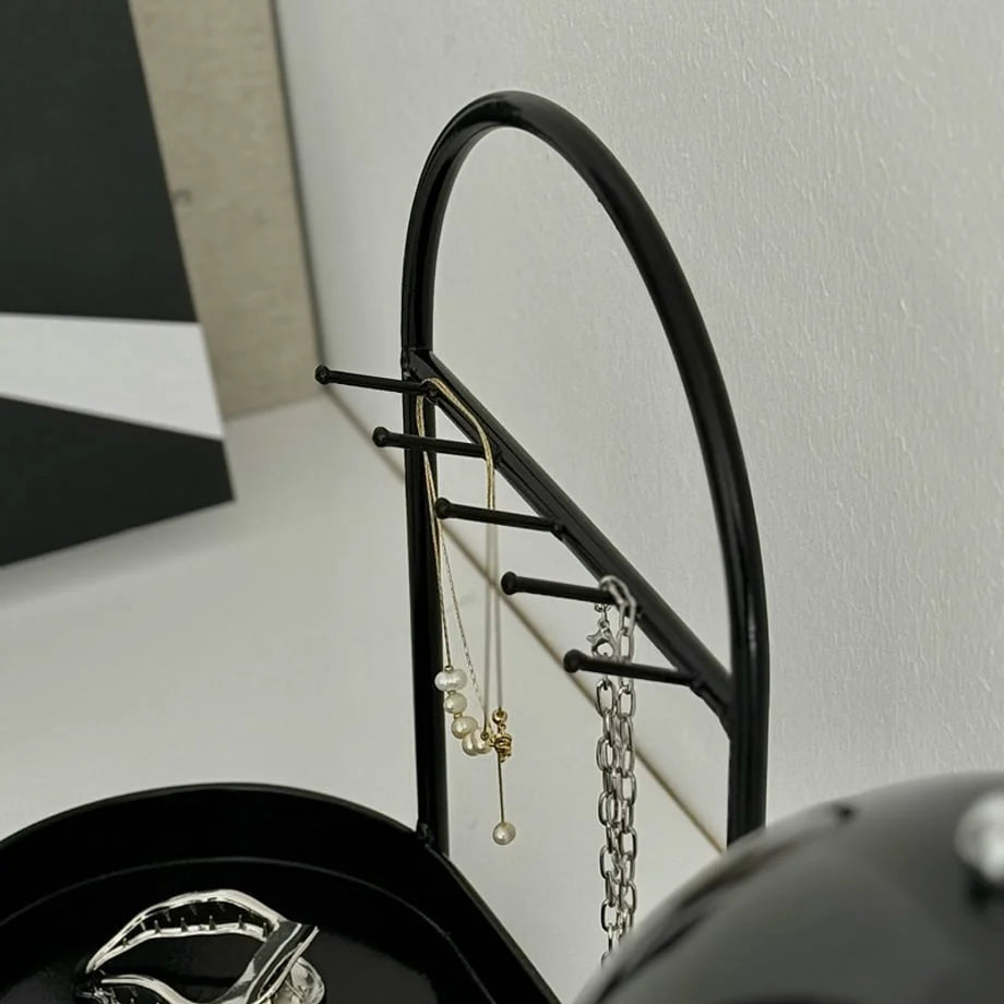 Detail shot showing the arched frame and hooks of the black jewelry stand. - RoomDen
