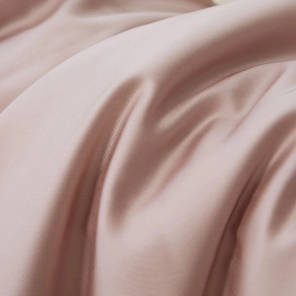 Detail shot of the buttery soft fabric folds of the Dusty Rose Cooling Tencel bedding.