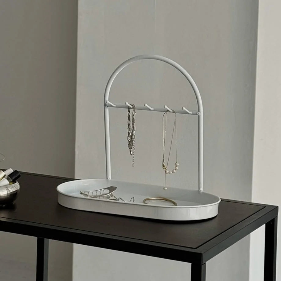 Angled view of the White Metal Jewelry Organizer holding necklaces and bracelets. - RoomDen