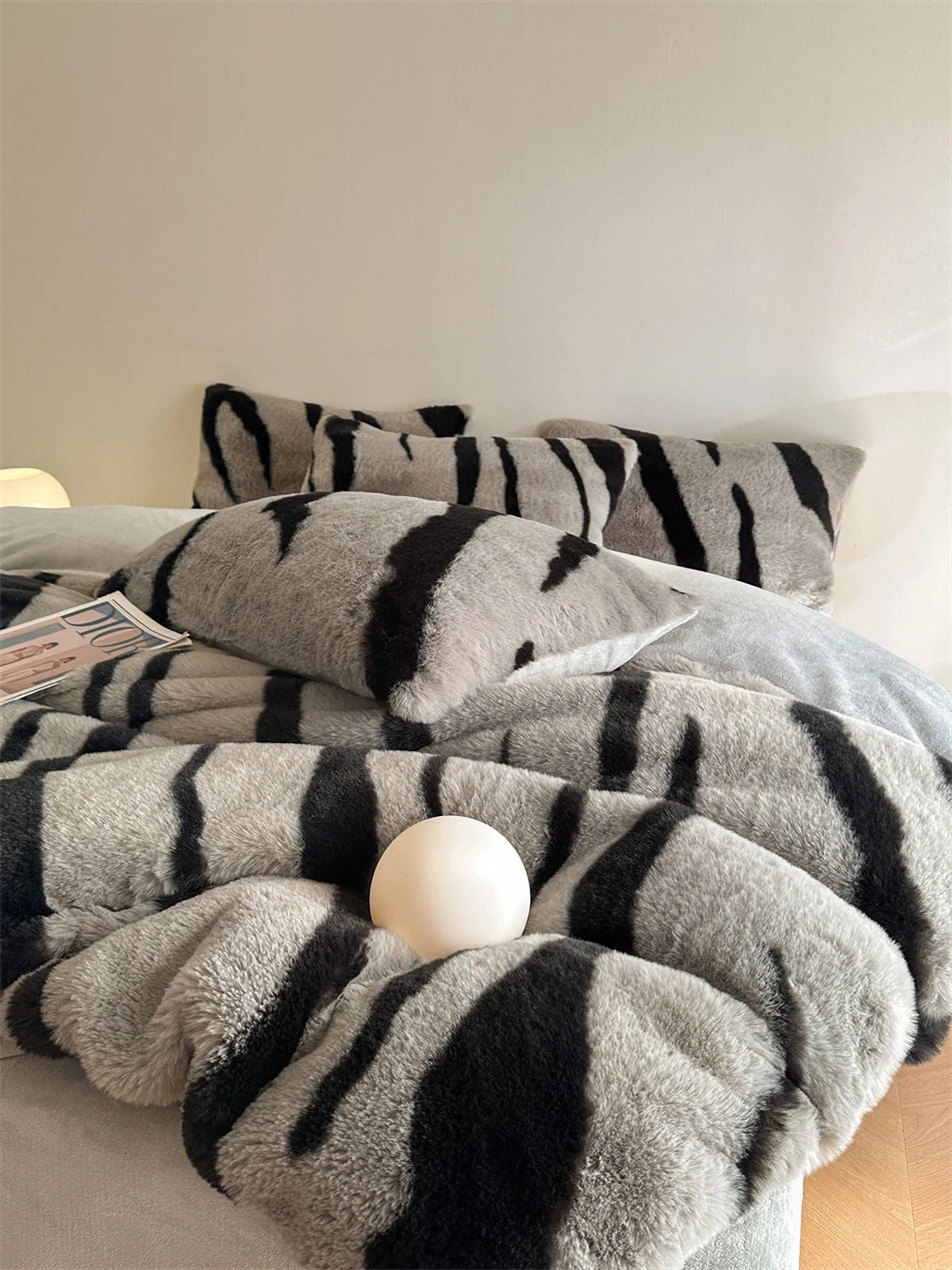 The Ash Grey and Black Tiger Stripe Fleece Bedding Set, with a focus on the plush pillowcases and a decorative white sphere. - RoomDen