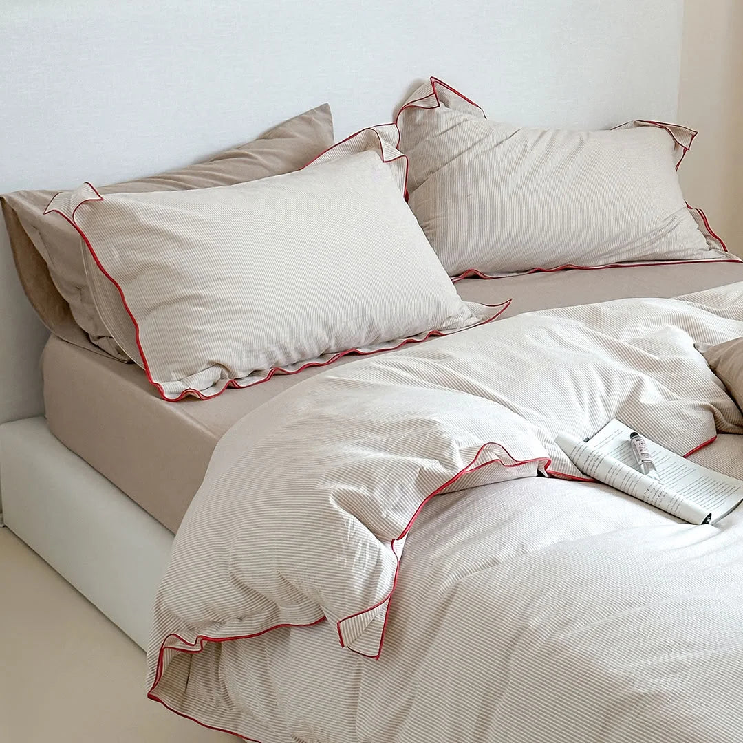 Close-up on the pillows of the Beige & Red Pinstripe Washed Cotton Bedding Set, showing the red trim.