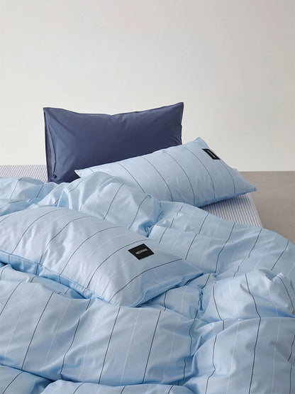 Detail shot of the Sky Blue Pinstripe duvet cover and pillowcases, emphasizing the soft, crinkled texture - RoomDen.