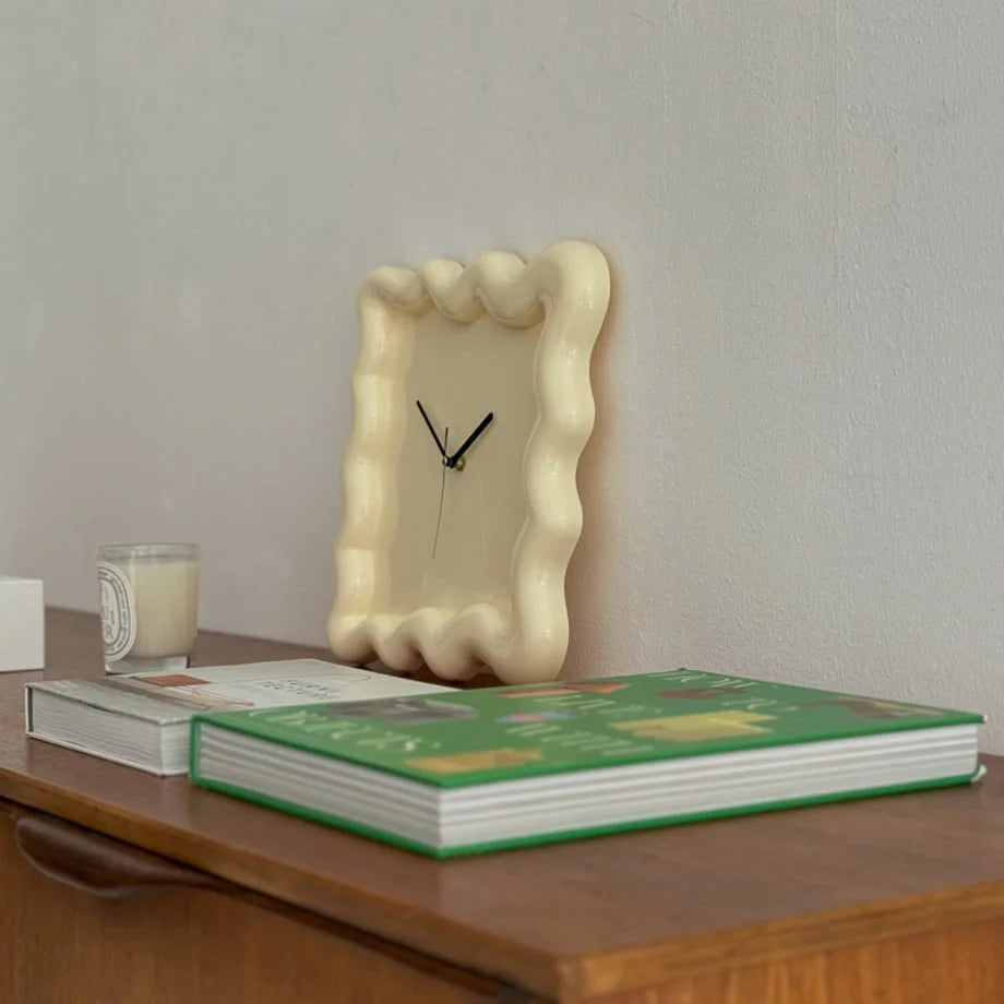 Close-up of the cream Wavy Squiggle Clock on a console, showing its soft color in a cozy setting. - RoomDen