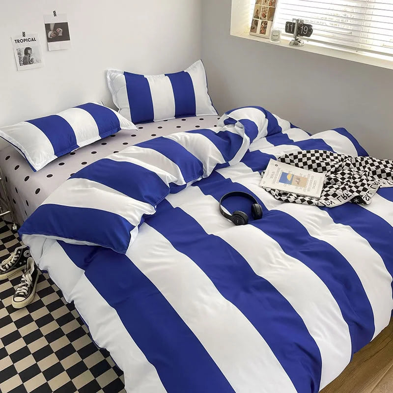Bold Blue & White Striped Bedding Set on a bed with a polka dot sheet and checkered floor - RoomDen