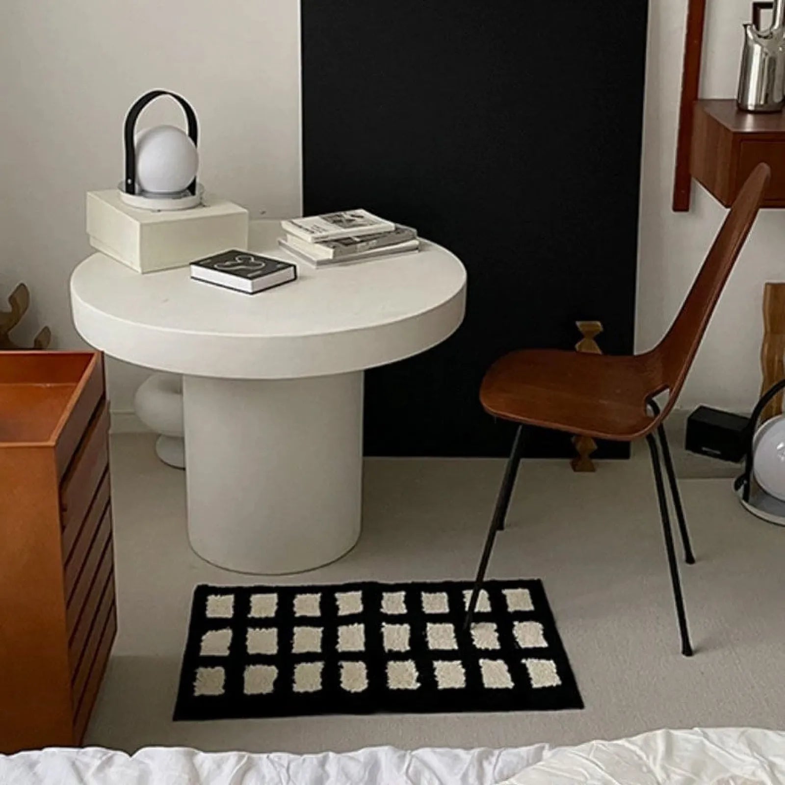 Black shaggy block-grid accent rug styled in a dark industrial setting with raw flooring - RoomDen
