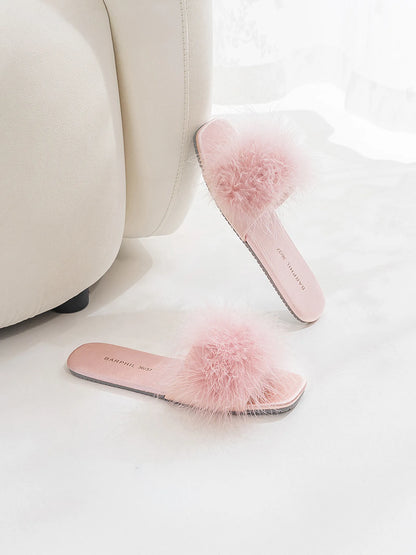 Lavender house slippers styled next to a cream sofa - RoomDen
