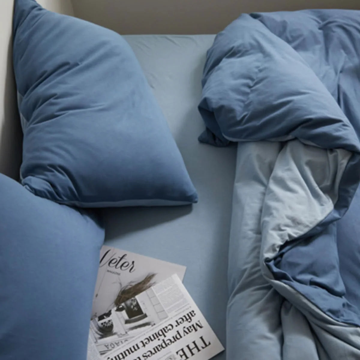 Aesthetic Flat Lay of Blue Jersey Bedding with Magazine - RoomDen