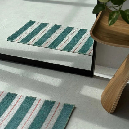 Reflection of green striped PVC coil rug in a floor mirror showing texture - RoomDen