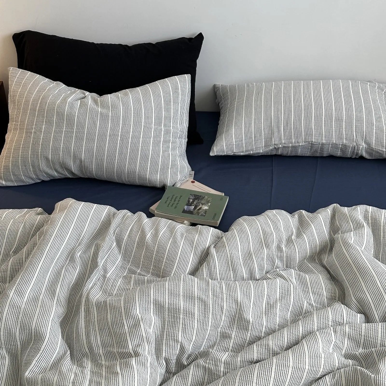 Grey and white pinstripe washed cotton bedding set on a dark blue sheet, showing the alternate color variant - RoomDen.