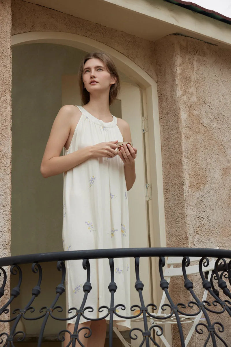 Woman standing on balcony holding cup in embroidered cotton sateen sleep dress - RoomDen
