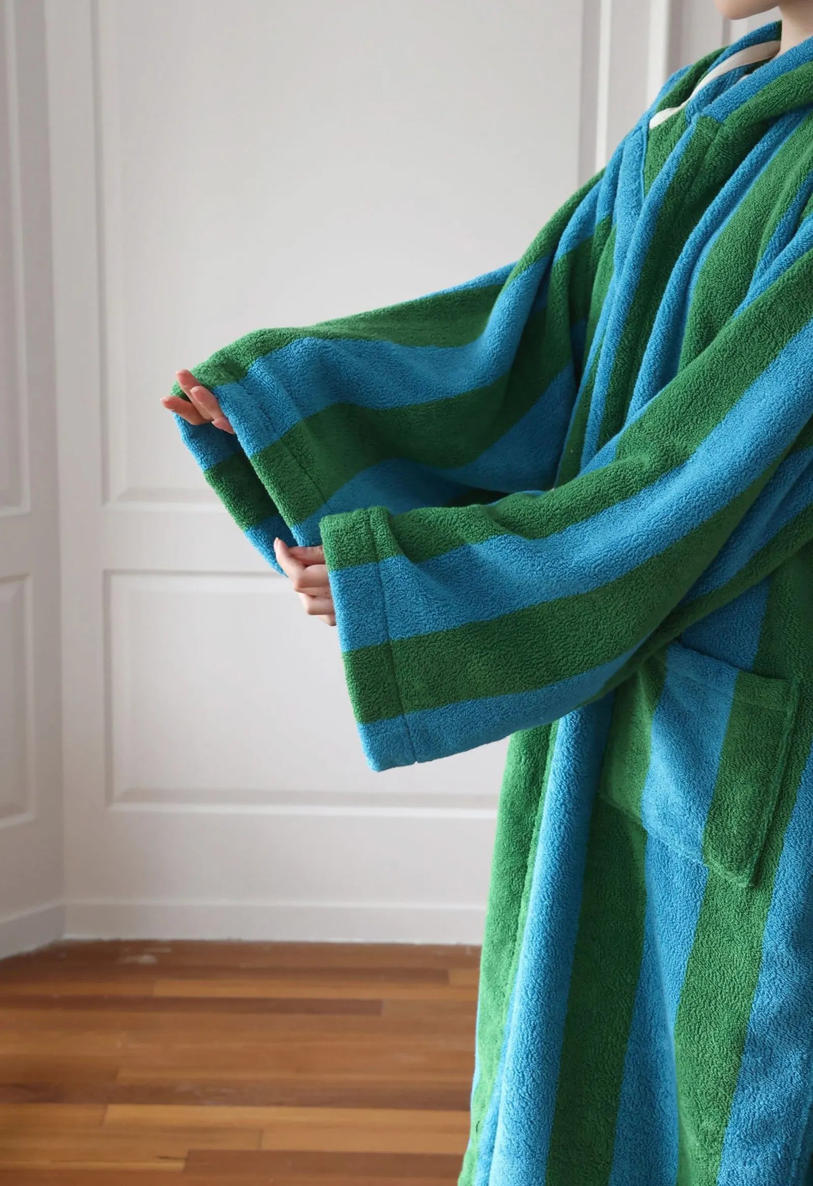 Close-up detail of the wide sleeves and terry texture on the striped cotton robe - RoomDen