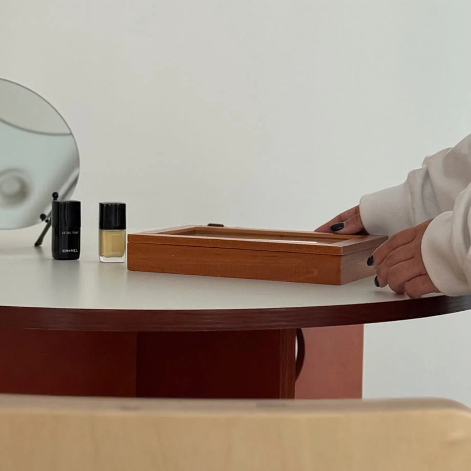 Side view of a closed wood jewelry organizer on a white and terracotta desk. - RoomDen