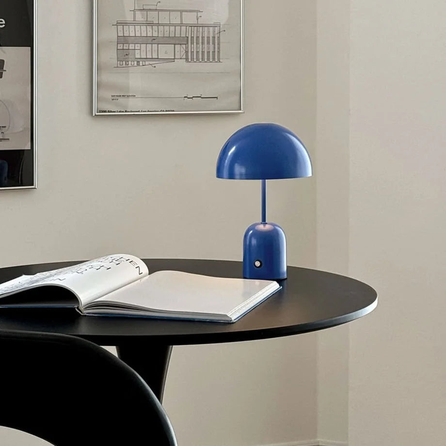 Cobalt Blue mushroom table lamp sitting on a black circular desk with an open book - RoomDen