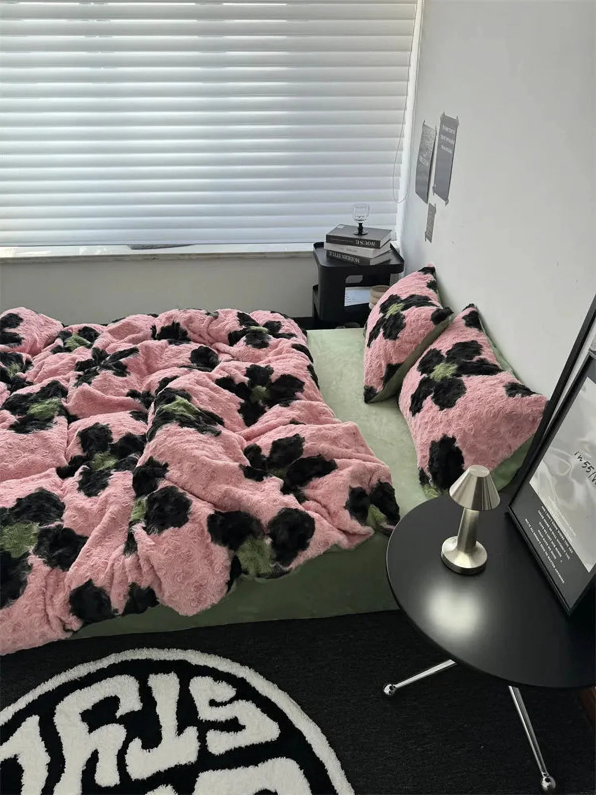 Side view of the cozy pink and black floral fleece duvet cover, showcasing its plush texture next to a black side table. - RoomDen