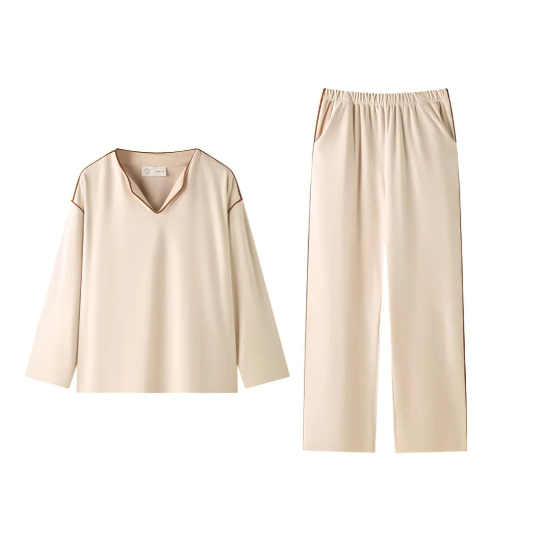 Flat lay of the soft piped plush pajama set in creamy beige, showing the V-neck top and wide-leg pants. - RoomDen