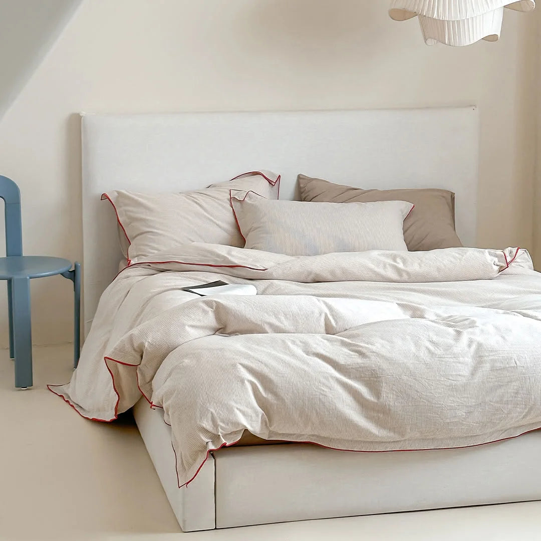 Angled shot of the Beige & Red Pinstripe Washed Cotton Bedding Set in a minimalist setting.