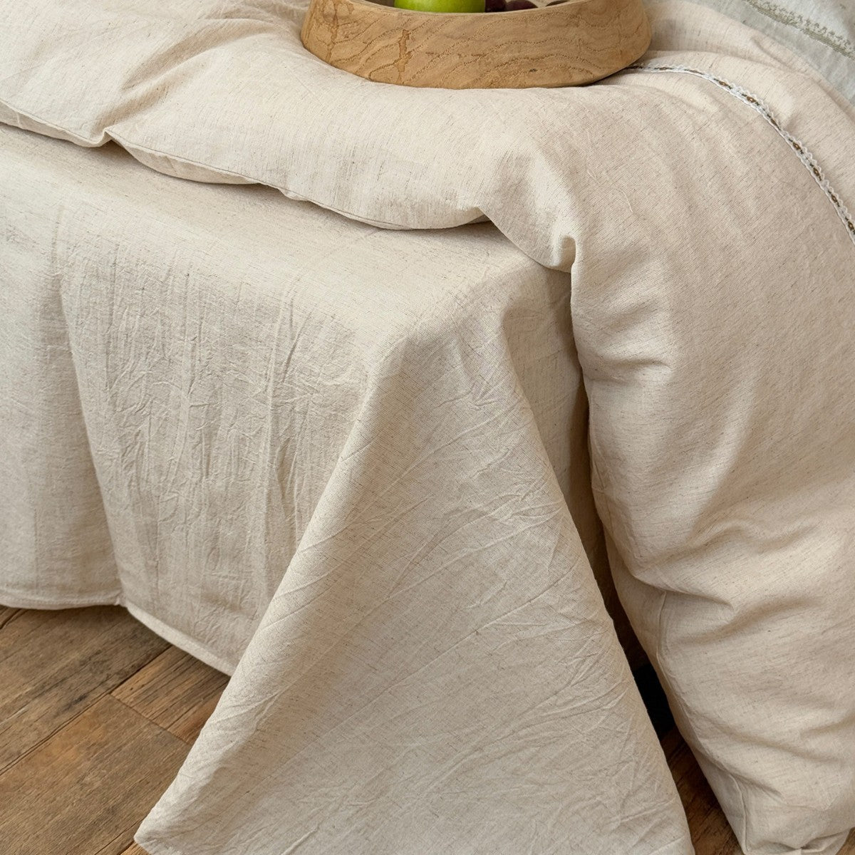 Meriwyn Botanical Linen-Cotton Bedding Set – natural-coloured sheet draped over the side of the bed - Roomden