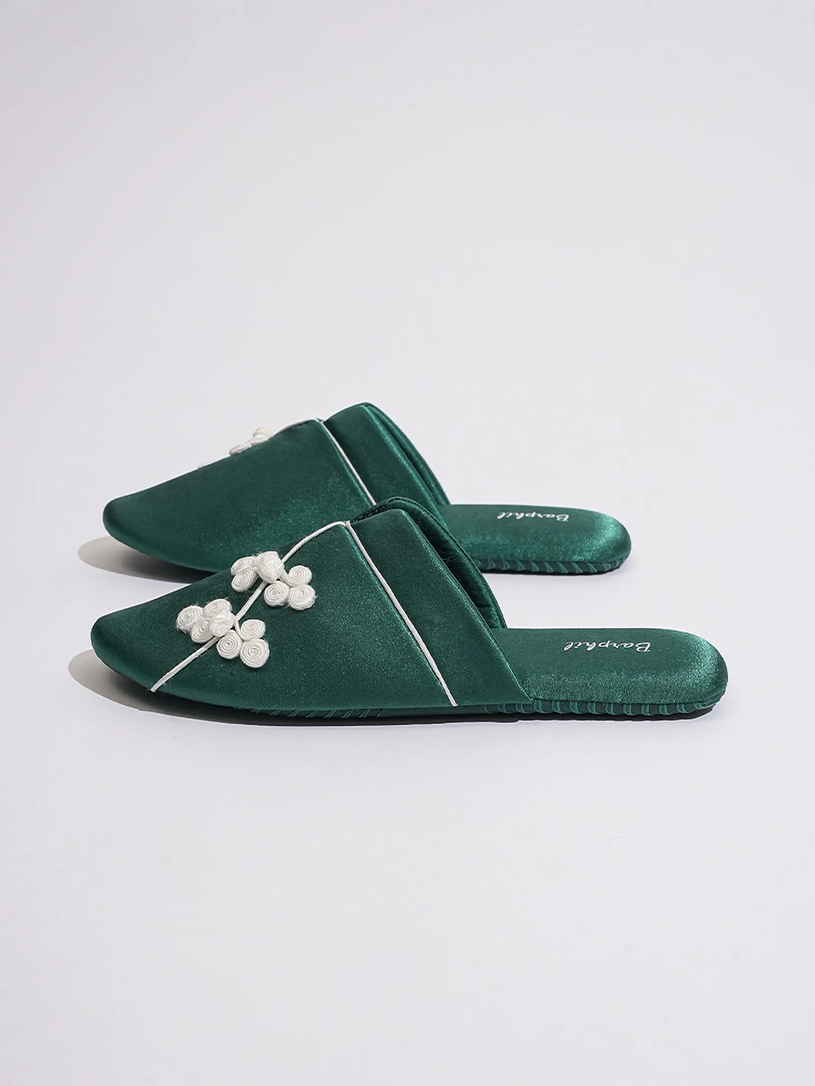 Side view of Green slippers displaying sleek silhouette and flat sole - RoomDen