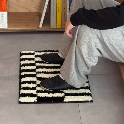 Lifestyle shot of feet resting on a soft black and white striped shaggy rug - RoomDen