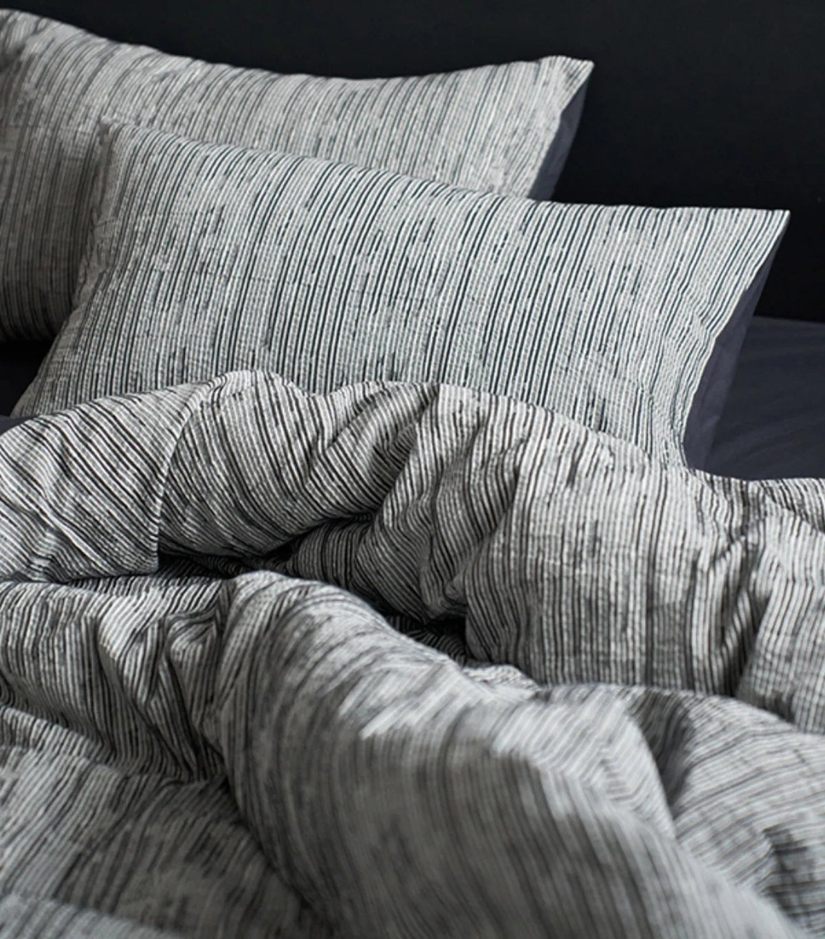 Detailed shot of the Ash Grey pinstripe pillowcases, emphasizing the fine line pattern.