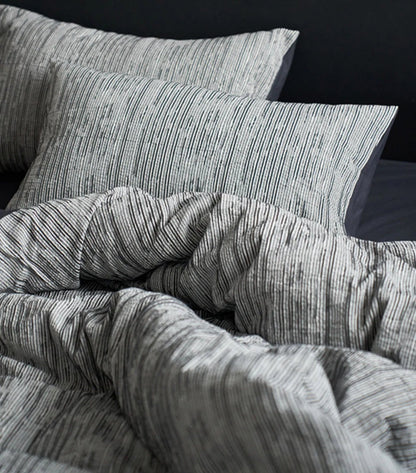 Detailed shot of the Ash Grey pinstripe pillowcases, emphasizing the fine line pattern.
