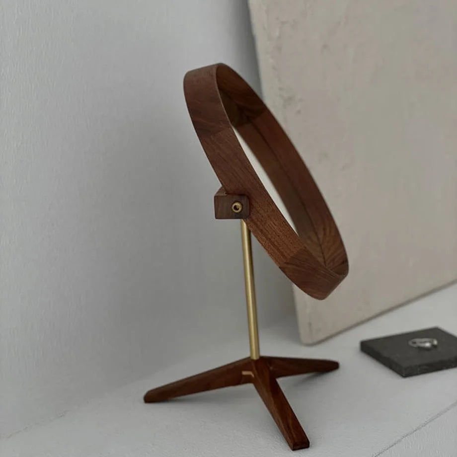 Side profile of the rotating round walnut desktop mirror, showing the brass swivel mechanism. - RoomDen