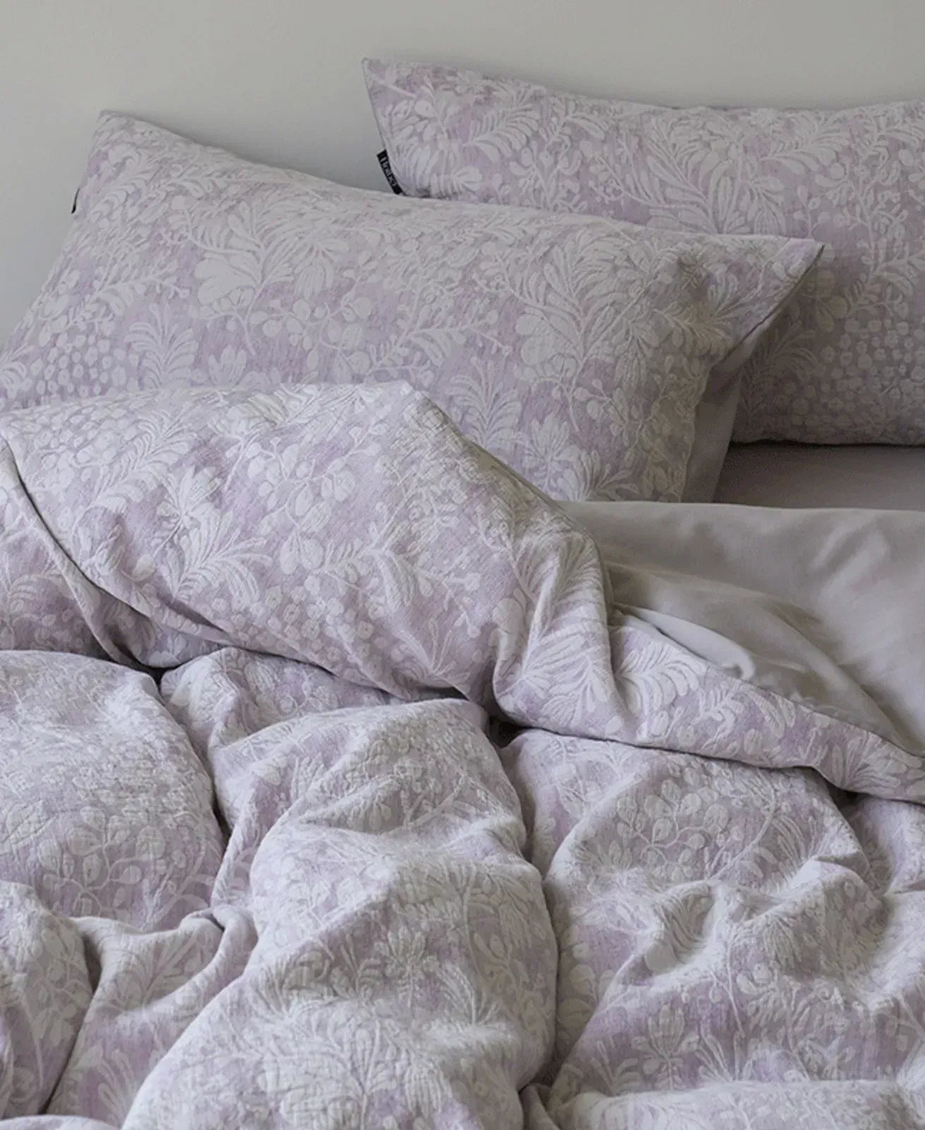 Close-up detail of the dusty lavender Jacquard Botanical Washed Cotton Bedding Set's intricate floral weave - RoomDen.