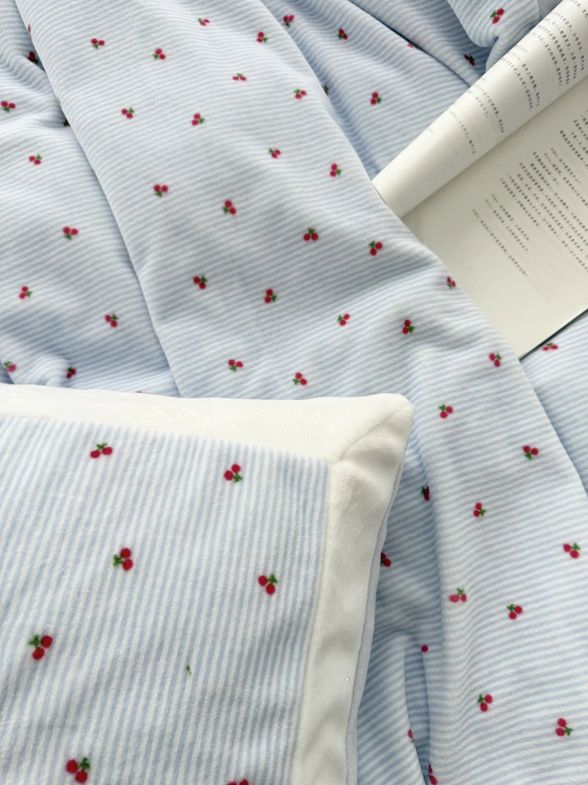 Angled view of the light blue cherry pinstripe bedding, highlighting the plush pillowcase and duvet cover - RoomDen.