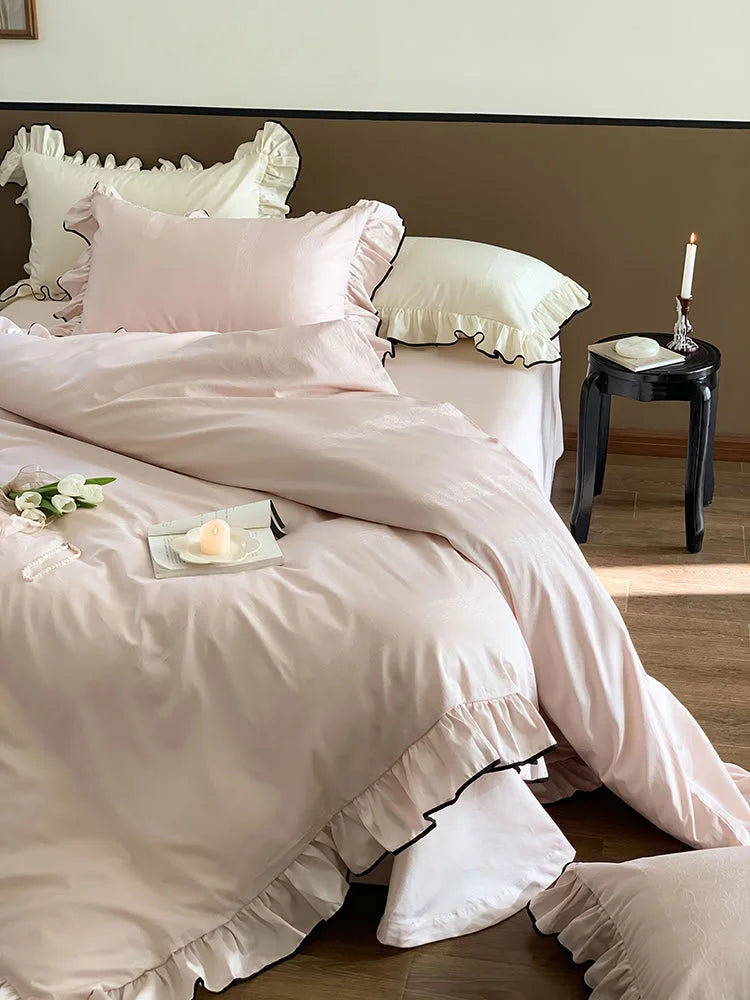 Angled view of the Blush Pink ruffled Tencel bedding, showcasing its drape and silky sheen in natural light - RoomDen.