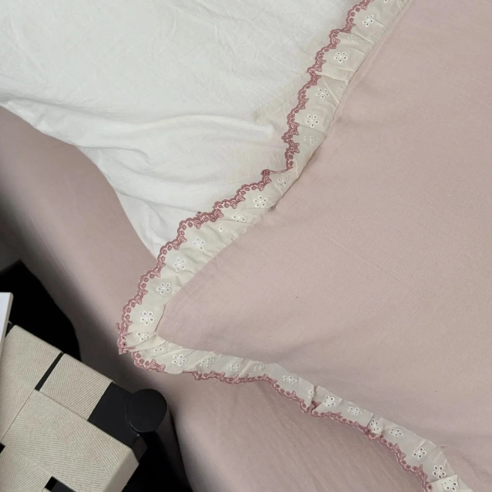 Overhead detail shot of the dusty rose pillowcase corner, showcasing the pink and white lace ruffle design.