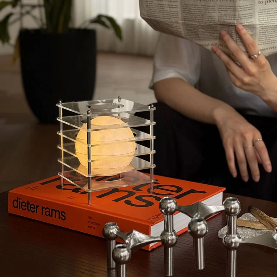 Side view of the Crystal Clear Caged Lamp illuminating a person's reading space - RoomDen
