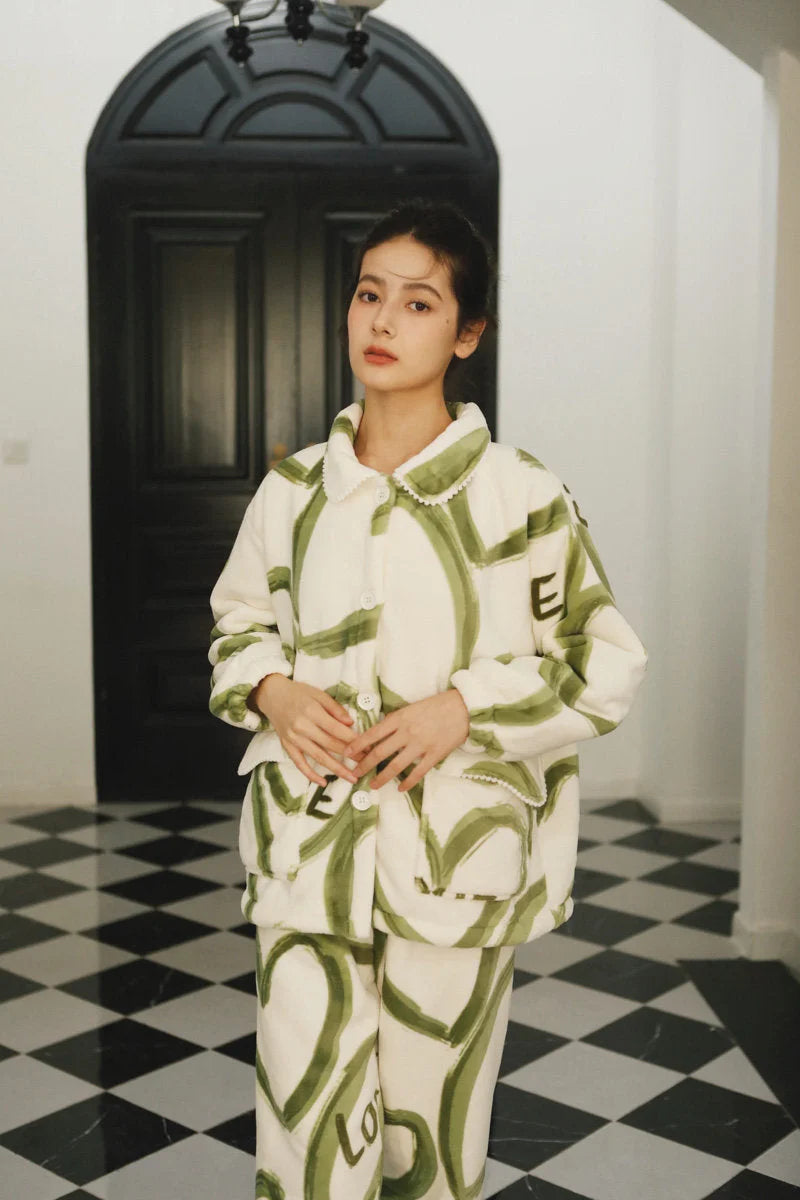 Model standing in front of a dark door, wearing the full two-piece graffiti fleece pajama set - RoomDen.