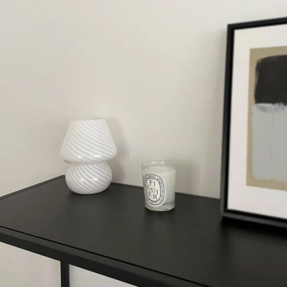 The Swirled Glass Mushroom Lamp unlit, showing its white swirl pattern on a dark surface.