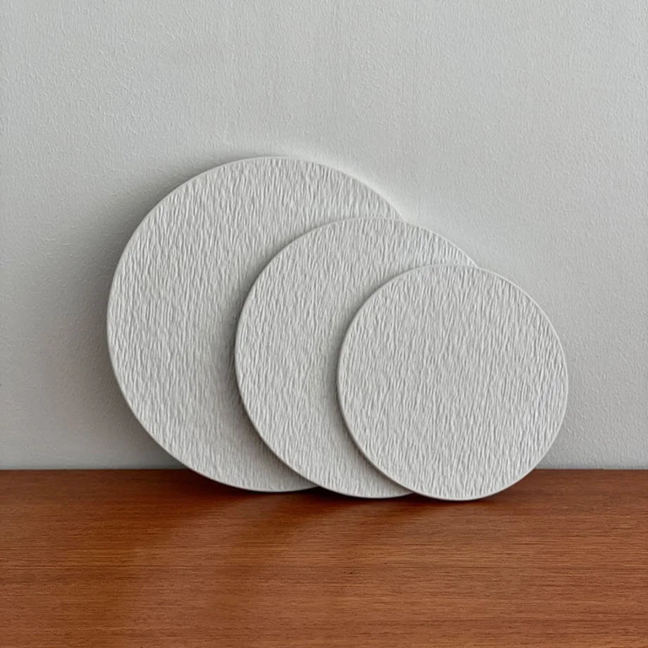 The three textured ceramic trays standing upright and overlapping to showcase their profile and surface detail. - RoomDen