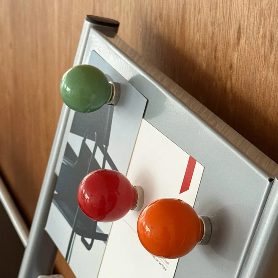Angled view showing the glossy finish on the green, red, and orange magnetic hooks. - RoomDen