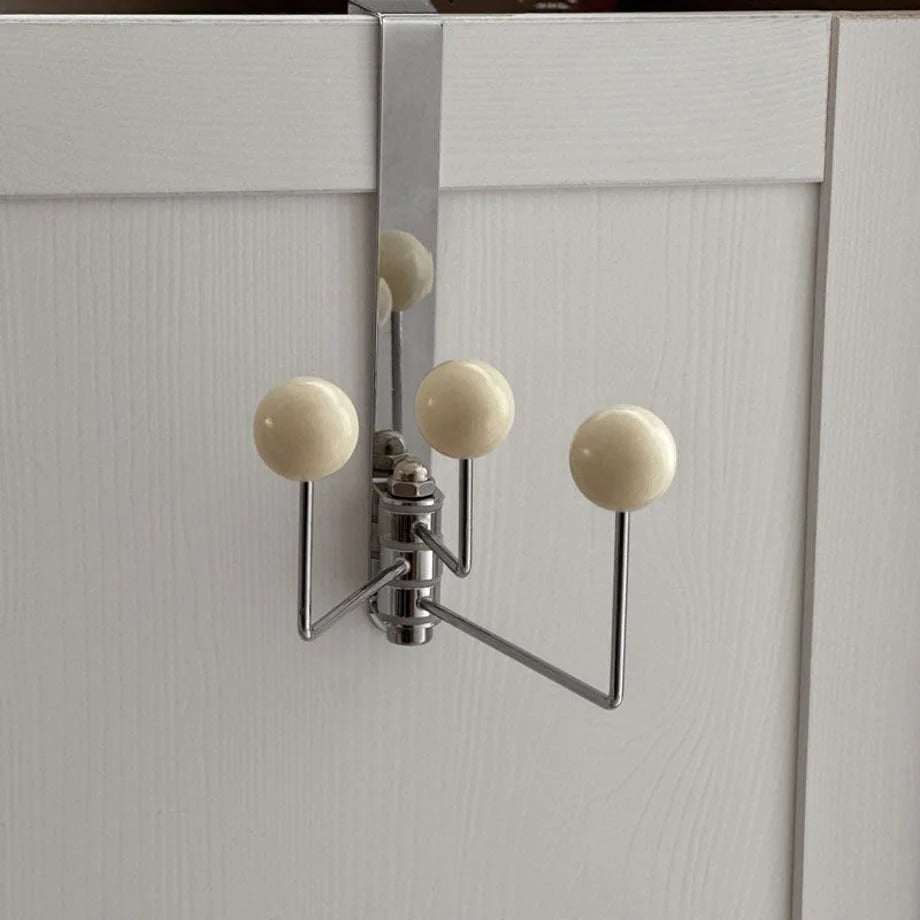 Close-up of the polished metal and three beige ball tips on the versatile door hook - RoomDen