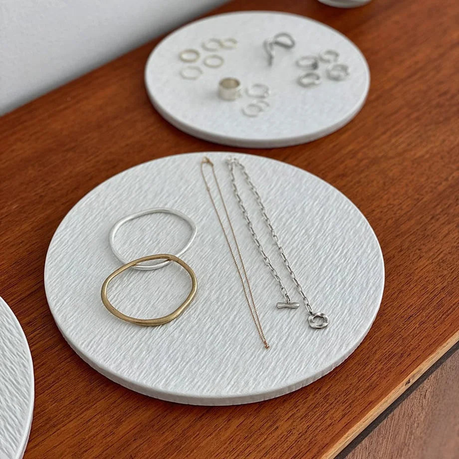 Close-up of the medium-sized textured ceramic tray holding bracelets and necklaces. - RoomDen