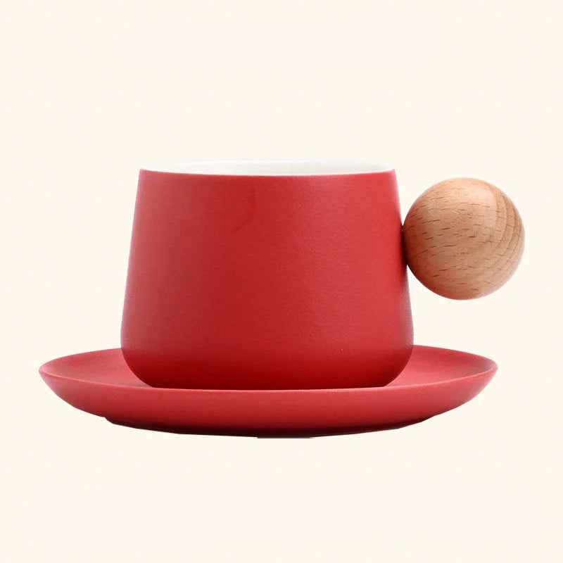 A studio shot of the Red Frosted Ceramic Mug and Saucer Set with a wooden ball handle. - RoomDen