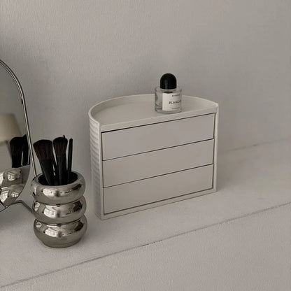 Angled view of the closed cream white makeup organizer, showing its ribbed texture. - RoomDen