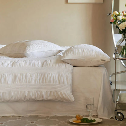 Side view of the Classic White pintuck bedding, showing the pillowcases and duvet cover edge.