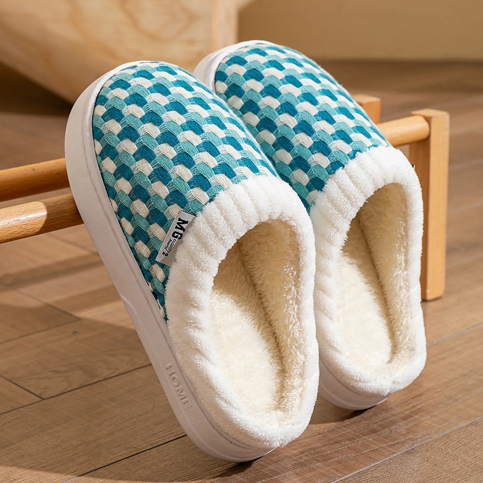 Pair of cyan woven plush slippers resting on wooden rack