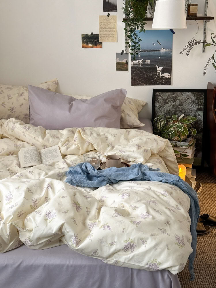 Cream bedding set with lavender floral print and lilac pillowcases in cozy bedroom – RoomDen
