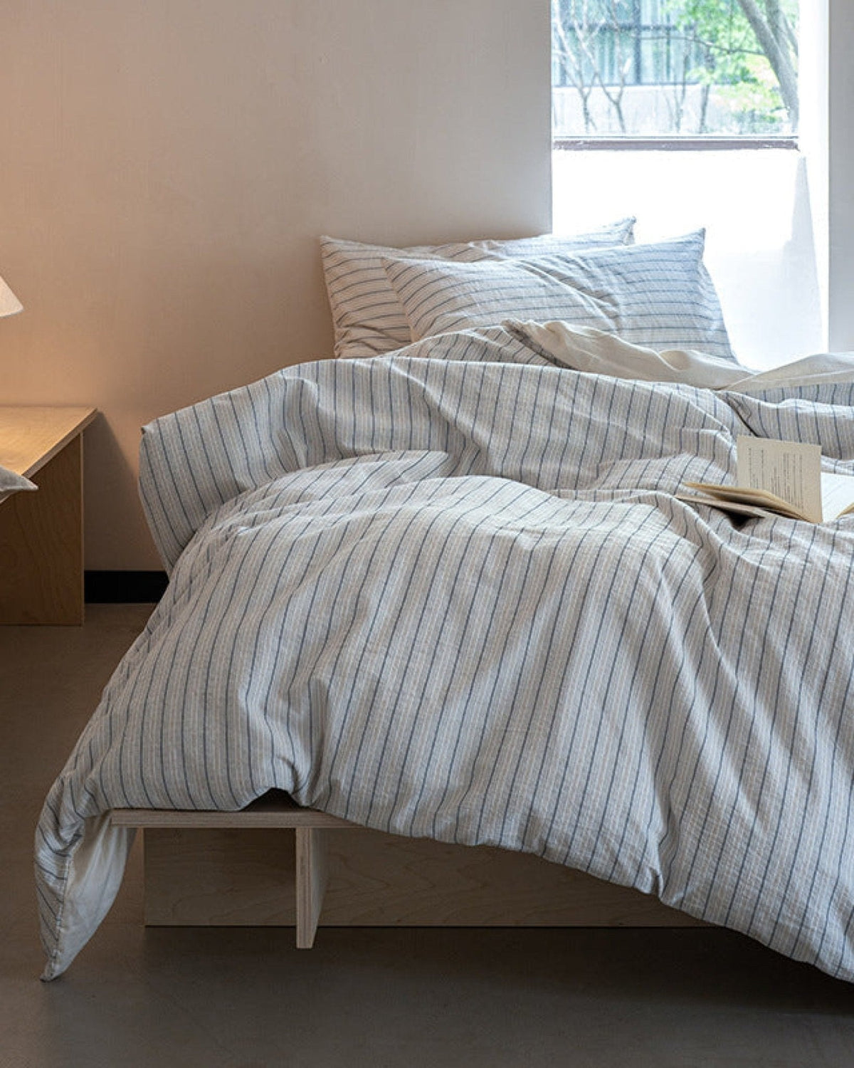 Winslet Pinstripe Cotton Bedding Set – striped duvet draped over a white bed frame - Roomden