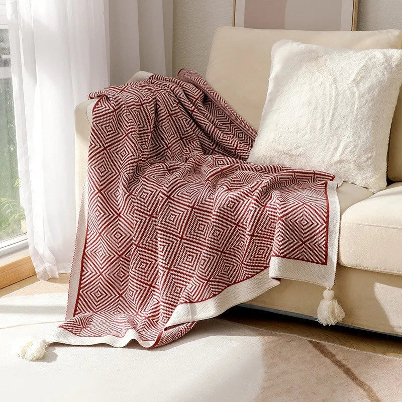 Black and white diamond knit fleece throw blanket draped over a wooden chair - RoomDen