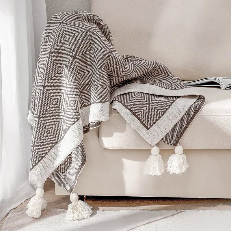 Black and white diamond knit fleece throw blanket draped over a wooden chair - RoomDen