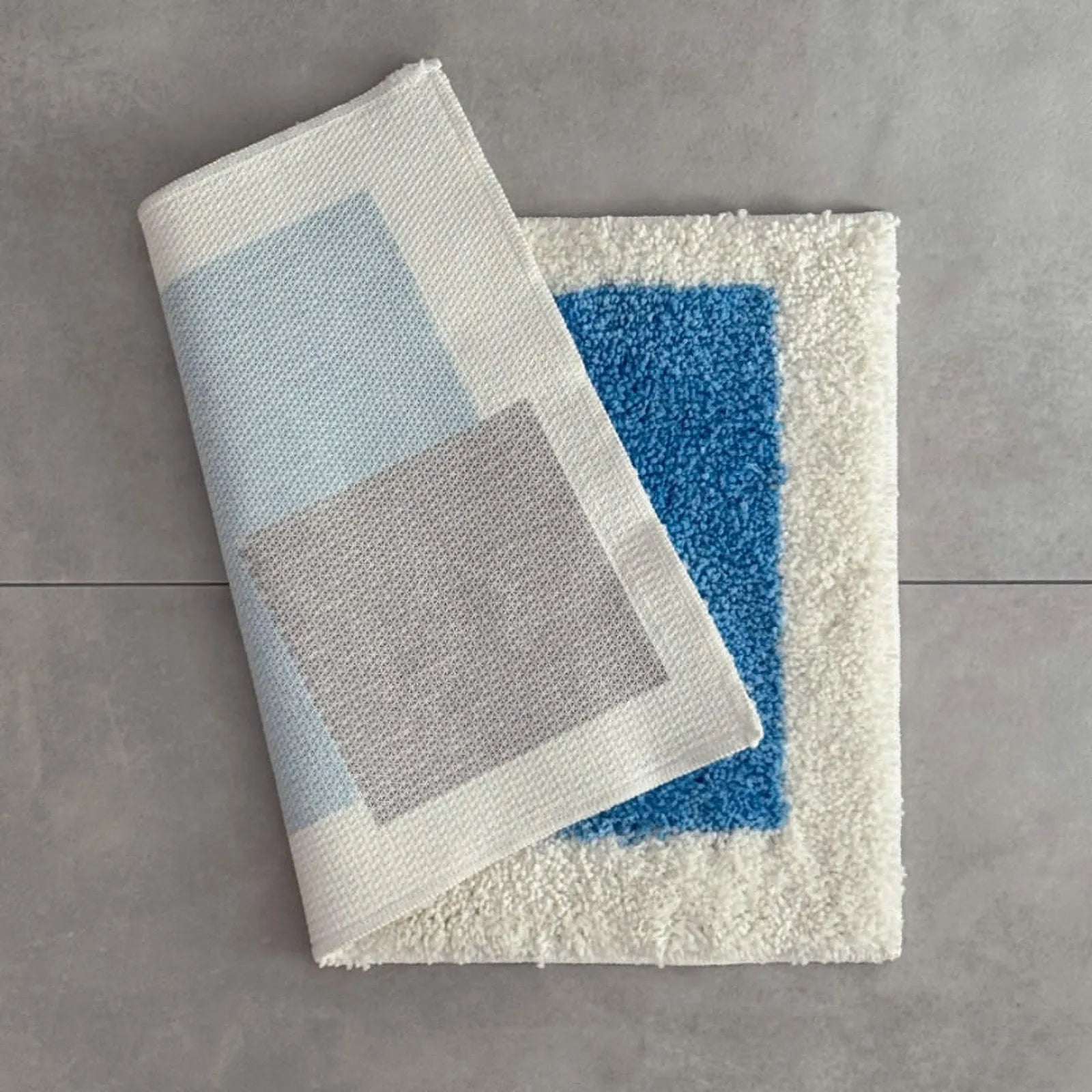 Folded Modern Color Block Plush Accent Rug showing the white non-slip TPR backing and thick tufted pile - RoomDen