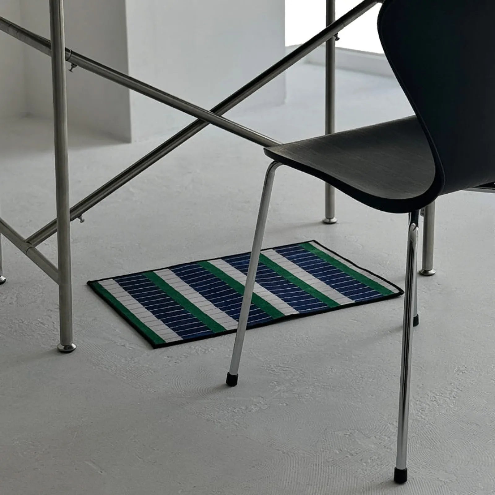 Wide shot of RoomDen blue and green geometric striped rug styling a home office space.