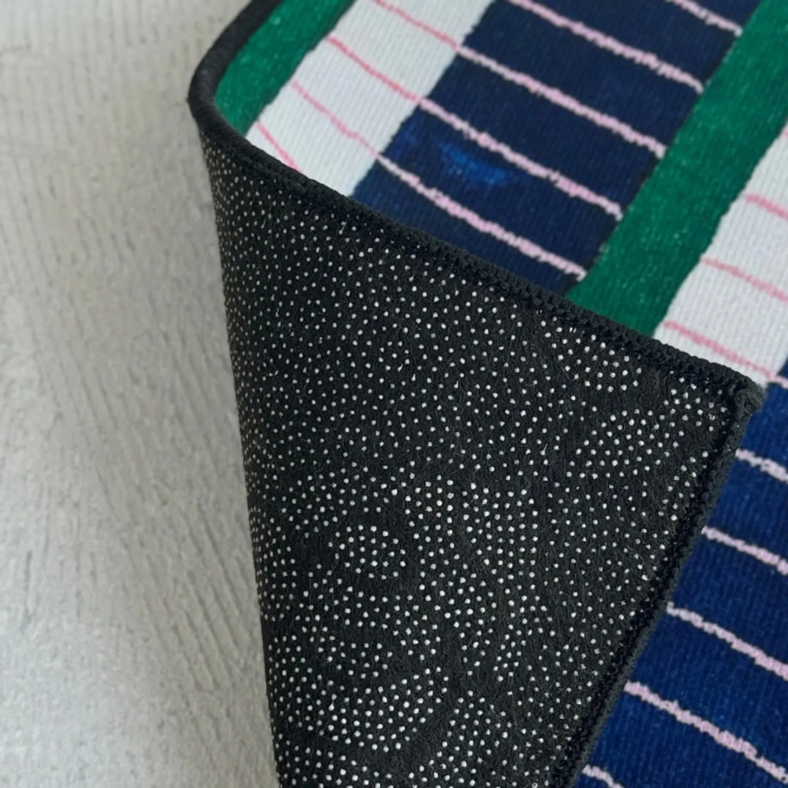 Detail view of the durable TPR non-slip backing on the RoomDen accent rug.