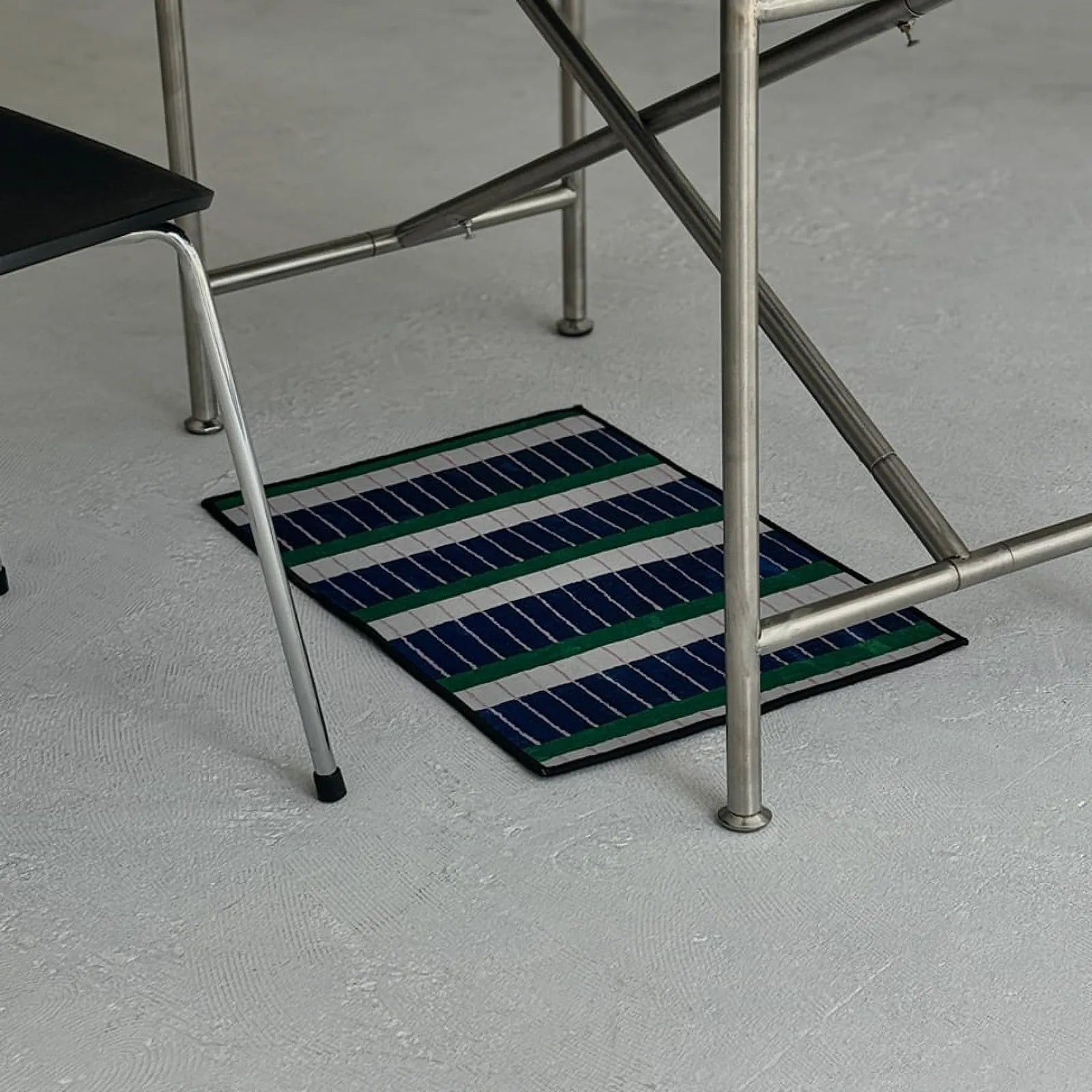 RoomDen rectangular accent rug with linear color block pattern sitting under a desk frame.