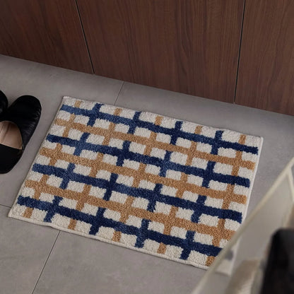 Top-down view of the grid pattern rug placed near black slippers - RoomDen